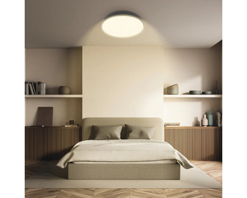Sovrum med säng och rund taklampa