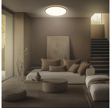 Vardagsrum med taklampa, soffa, kuddar och trappa