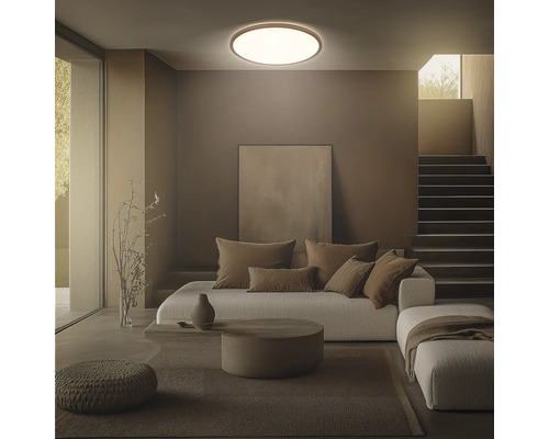 Vardagsrum med taklampa, soffa, kuddar och trappa