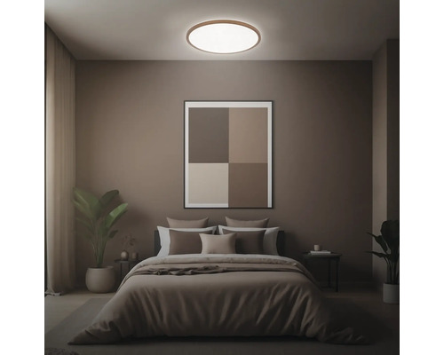 Sovrum med säng, sängbord, krukväxter, taklampa och inramad bild på väggen