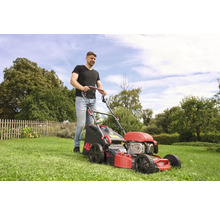 Man klipper gräsmattan med en AL-KO gräsklippare i trädgården.