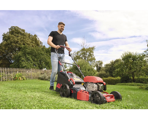 Man klipper gräsmattan med en AL-KO gräsklippare i trädgården.