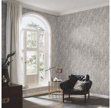 Vardagsrum med mönstrad tapet, fåtölj och fönster