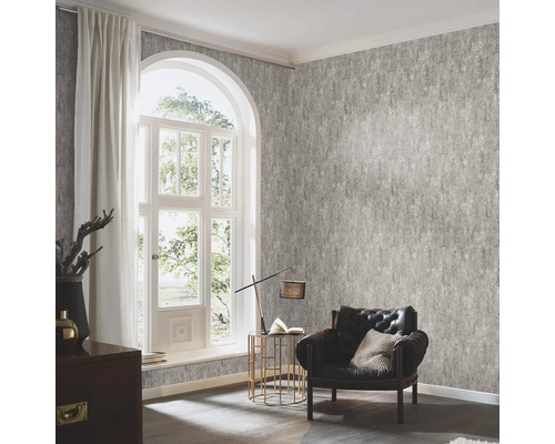 Vardagsrum med mönstrad tapet, fåtölj och fönster