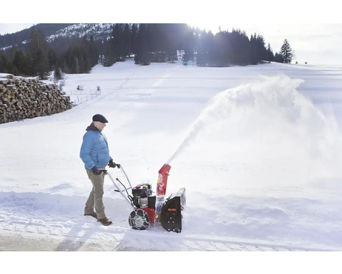 En person använder en AL-KO snöslunga för att röja snö.