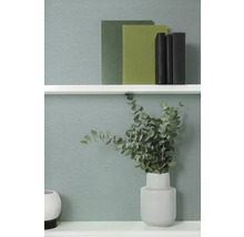 Dekorativ hyllscen med böcker och en vas med eukalyptus