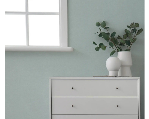 Byrå med dekorationer framför en vägg bredvid ett fönster