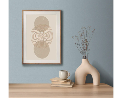 Dekorativt stilleben med inramat konsttryck, böcker, kopp och vas på ett bord