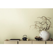 Dekorativ scen med tekanna, bok och grenar i vas på en skänk