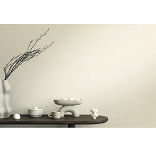 Dekorativ scen med vas, grenar, skål och keramiska figurer på ett bord