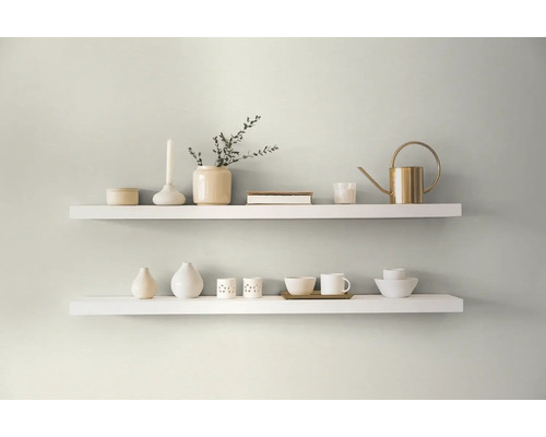 Två vita hyllor med dekorativa föremål på en vägg