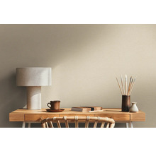 Scen med skrivbord, lampa och målartillbehör framför en vägg