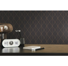 Dekorativt rum med geometrisk tapet, bordslampa och skrivbordstillbehör