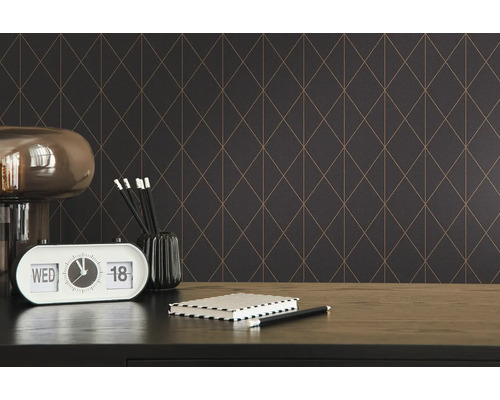 Dekorativt rum med geometrisk tapet, bordslampa och skrivbordstillbehör