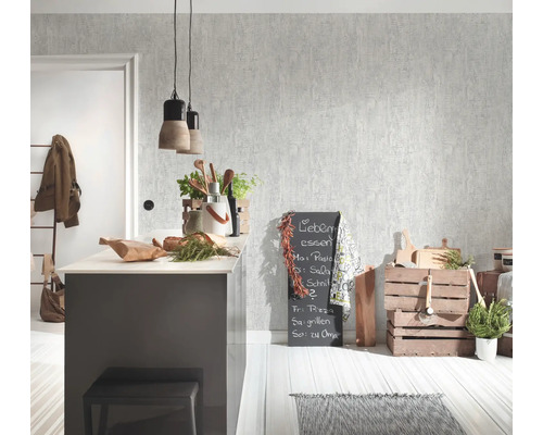 Vardagsrum med mönstrad tapet, köksö, griffeltavla och dekorationer