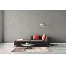 Modernt vardagsrum med grå strukturtapet, soffa, matta och golvlampa.