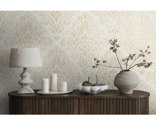 Scen med mönstrad tapet, lampa, ljus och dekorativ vas på en byrå