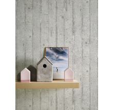 Dekorativ scen med betongtapet, trähylla, fotoram och fågelholk