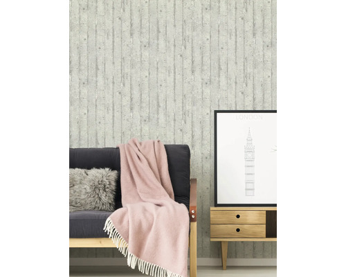 Vardagsrum med betongstruktur tapet, soffa, kudde, filt och sidobord med Londonbild