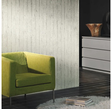 Vardagsrum med betongtapet, grön fåtölj och byrå