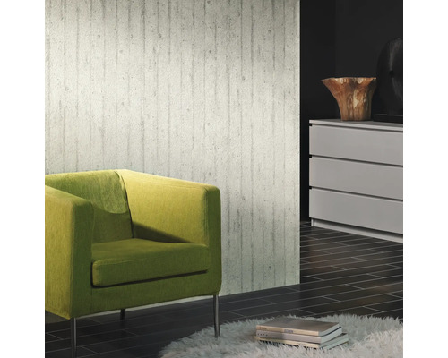 Vardagsrum med betongtapet, grön fåtölj och byrå