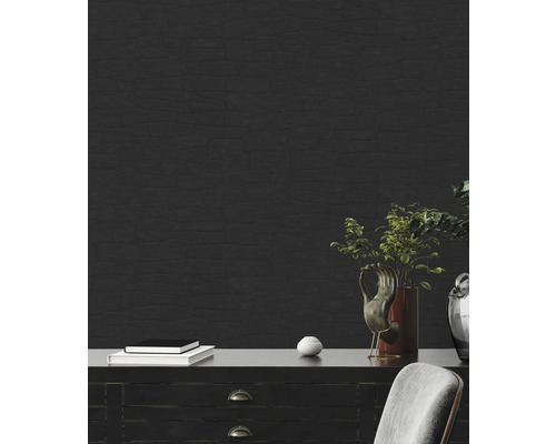 Rum med svart tapet i stenlook, byrå, böcker och dekorationer