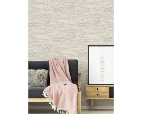 Vardagsrum med soffa, filt, kudde, byrå och tapet i stenimitation