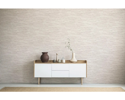 Vardagsrum med skänk, vaser och dekorativa föremål framför en mönstrad vägg