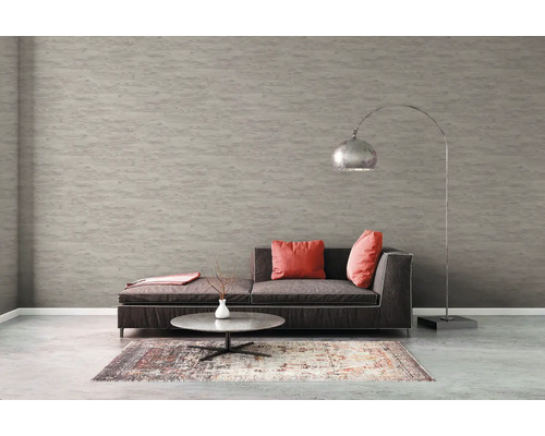 Vardagsrum med soffa, matta, bord och golvlampa framför en strukturtapet.