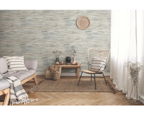 Vardagsrum med mönstrad tapet, soffa och fåtölj på en matta