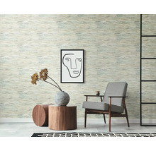 Scen med mönstrad tapet, fåtölj, konstverk och sidobord för rumdesign