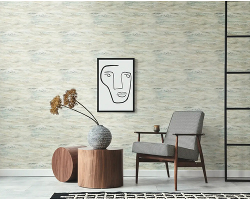 Scen med mönstrad tapet, fåtölj, konstverk och sidobord för rumdesign