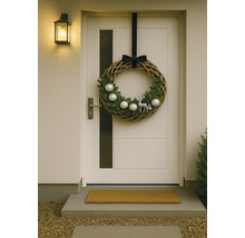 Dekorativ dörrkrans med julmotiv på en ytterdörr