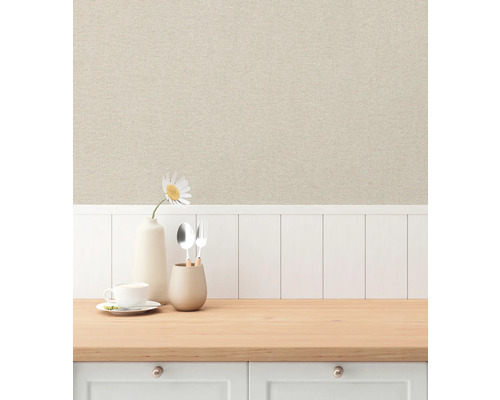Miljöbild med beige non-woven tapet i linne-look ovanför en vit träpanelvägg