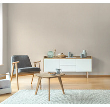 Vardagsrum med fåtölj, bord och byrå i ljus design