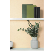 Dekorativ hylla med böcker och eukalyptus i vas.