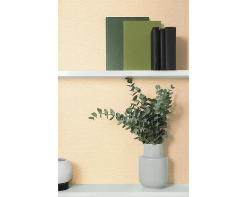 Dekorativ hylla med böcker och eukalyptus i vas.