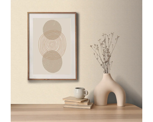 Dekorativ bild med cirkelmönster i träram, på ett bord med dekorativ vas och böcker