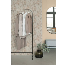 Klädställning med kläder, spegel och dekoration i ett rum.