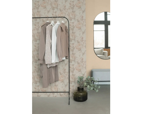 Klädställning med kläder, spegel och dekoration i ett rum.