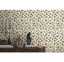 Dekorativt rum med tapet med leopardtryck och dekorativa föremål på ett skåp