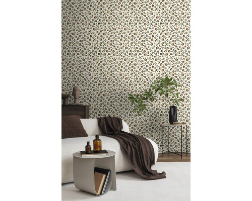 Vardagsrum med tapet i leopardmönster, soffa, sidobord och dekorationer.