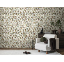 Vardagsrum med leopardmönstrad tapet, fåtölj och träbyrå