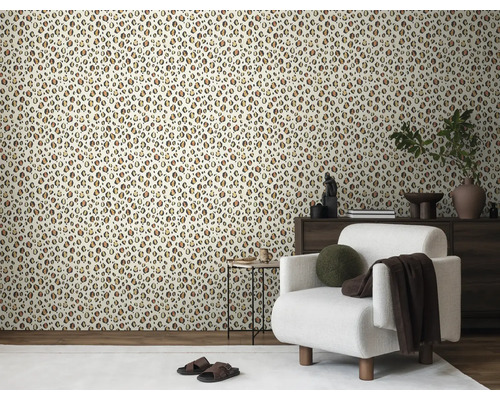 Vardagsrum med leopardmönstrad tapet, fåtölj och träbyrå