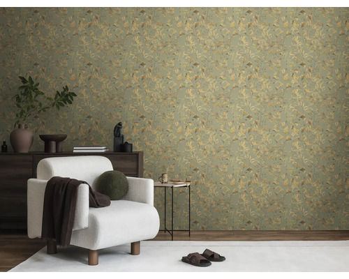 Vardagsrum med en grön tapet med växtmönster, en vit fåtölj och en mörk sidobord