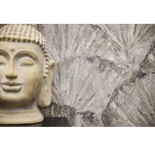 Dekorativ Buddha -staty framför en mönstrad vägg