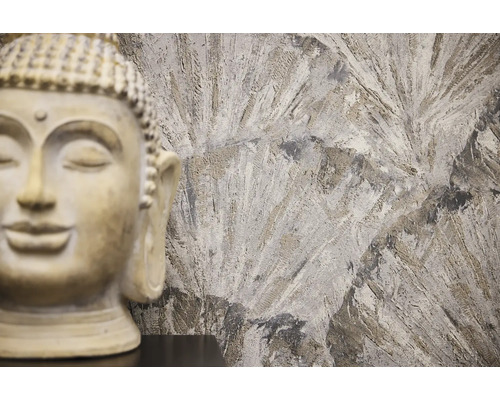 Dekorativ Buddha -staty framför en mönstrad vägg