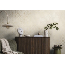 Dekorativt rum med mönstrad tapet, träskåp och dekorativa föremål