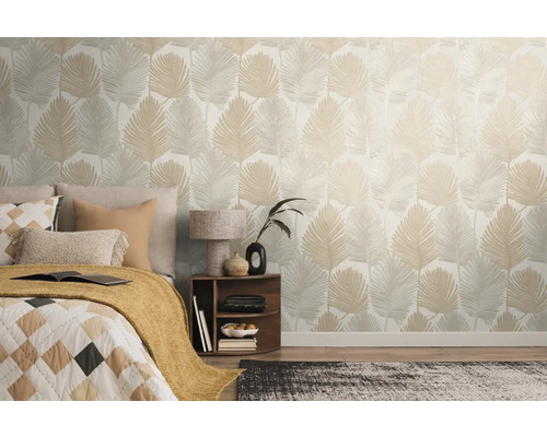 Sovrum med säng och en vägg med blad tapet.