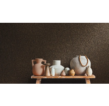 Olika vaser på ett bord framför en strukturerad vägg